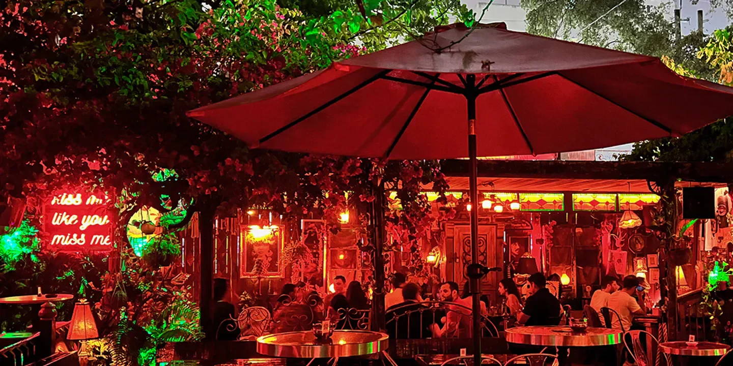 Boho House Miami: Romantic outdoor dining with vibrant red decor and cozy ambiance.