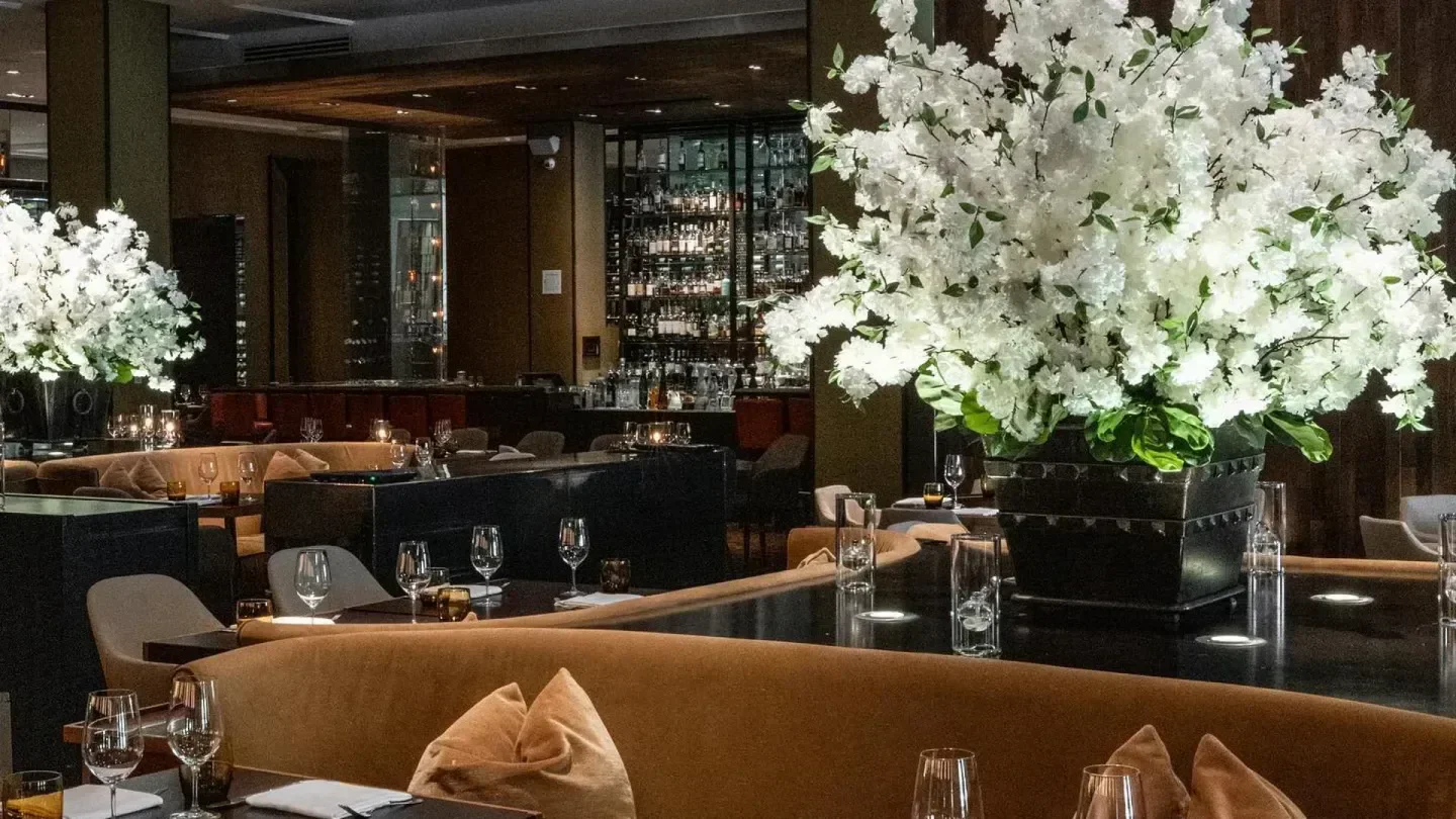 Elegant interior of Bourbon Steak Miami with floral arrangements and seating.
