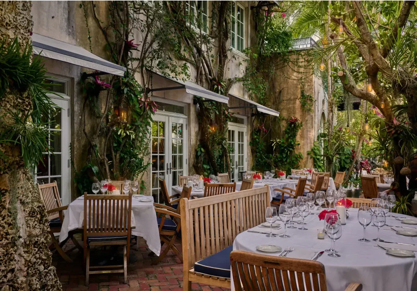 Casa Tua Miami's lush outdoor dining area in Miami, with tables set for a romantic dinner.