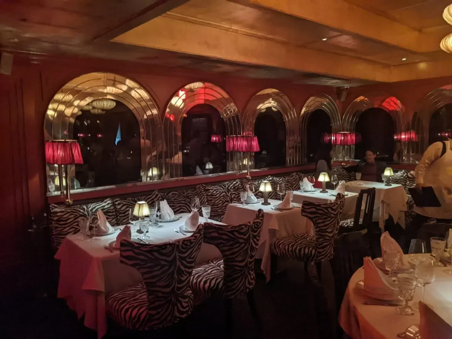 Interior of Dirty French Miami restaurant with zebra print chairs and mirrors.