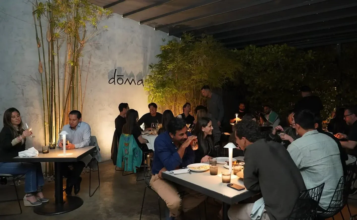 Dōma Miami restaurant's lively ambiance featuring indoor and outdoor dining with customers.