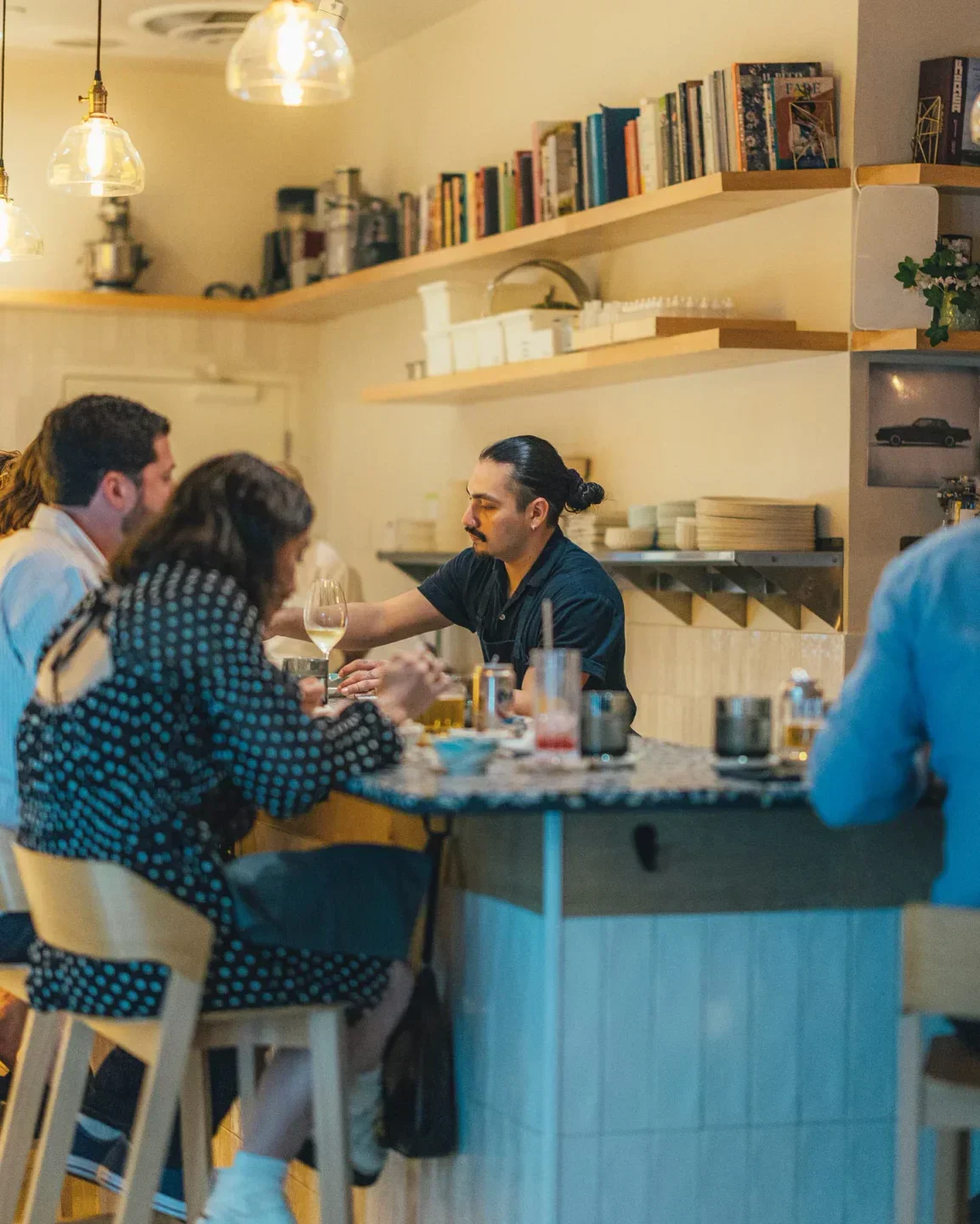 Cozy bar scene at Itamae AO in Miami, with guests enjoying drinks and atmosphere.