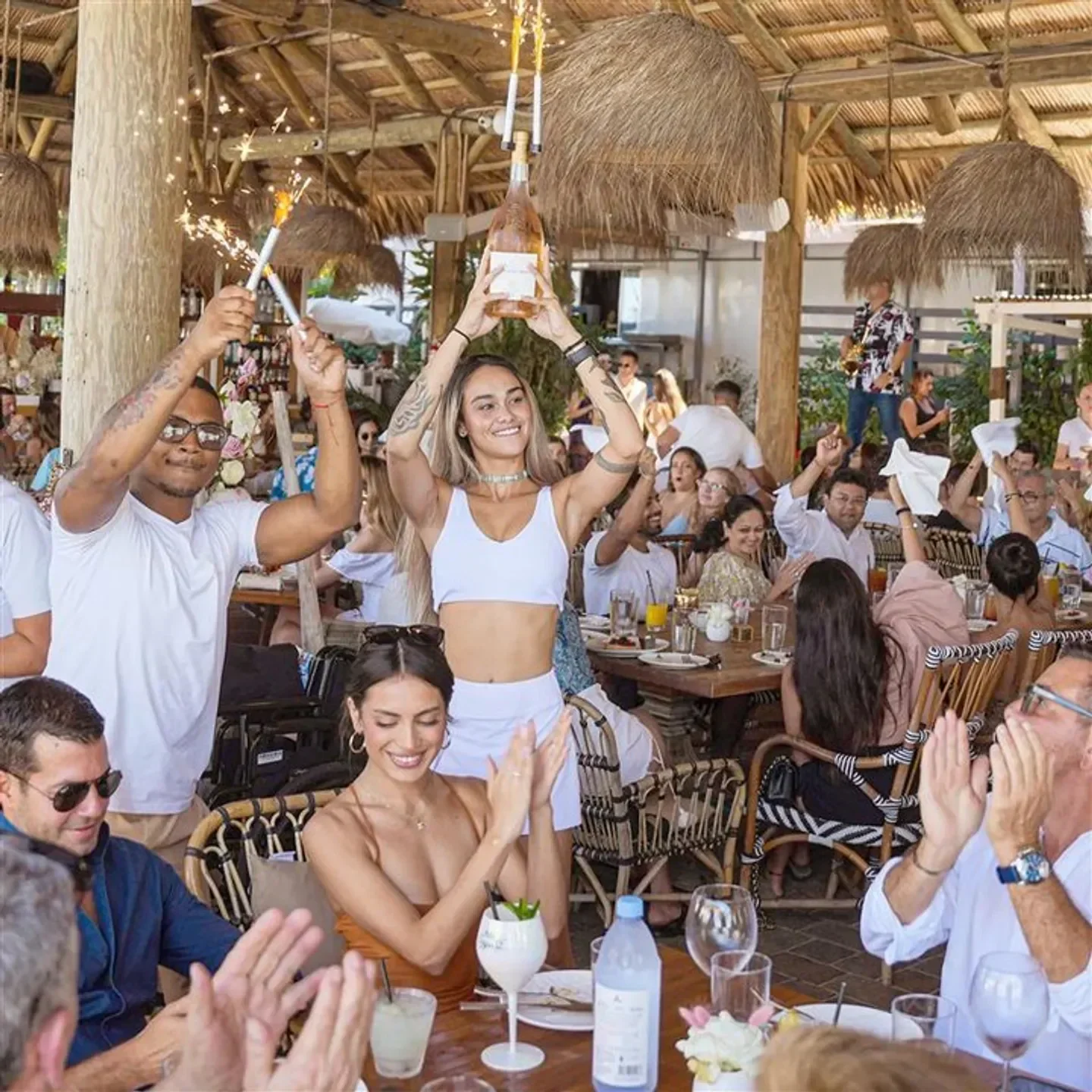 Celebration at Joia Beach Club in Miami with sparklers and raised bottle