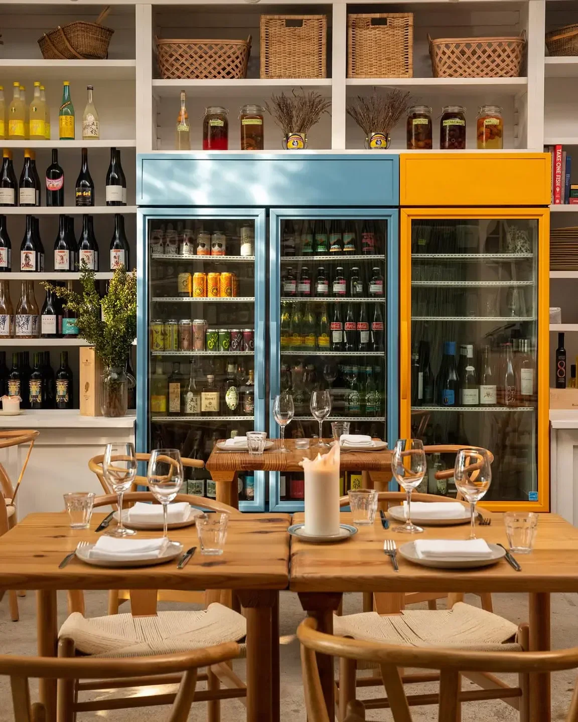 Elegant dining at Krüs Miami, featuring wooden tables and a colorful drink display.