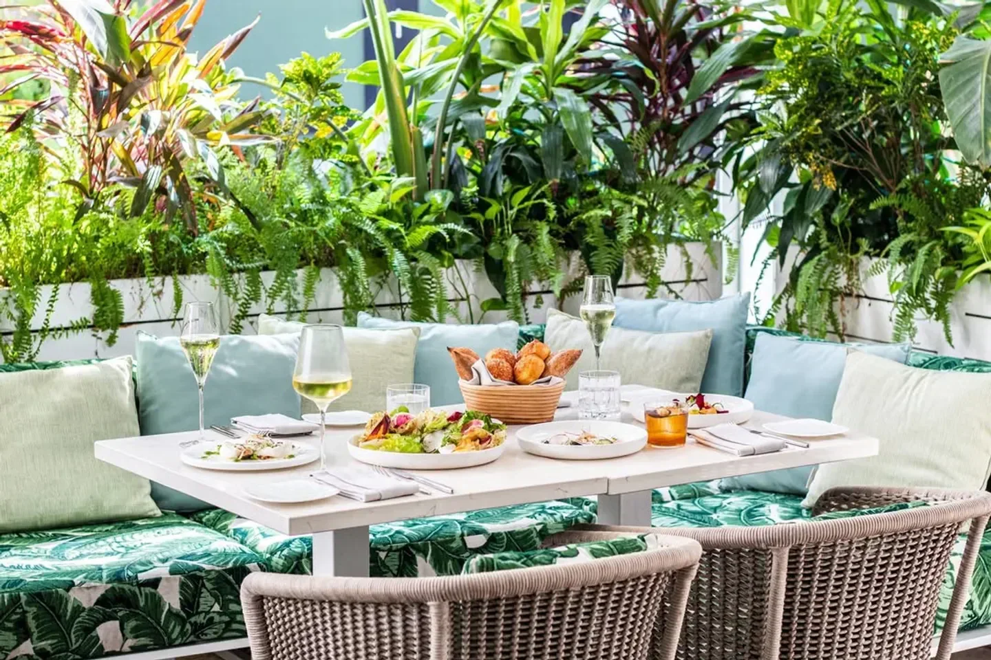Outdoor dining at Le Jardinier Miami, featuring lush greenery, in Miami