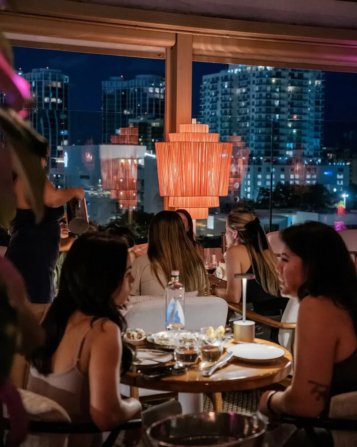 Level 6 Miami restaurant at night with city view and guests dining.