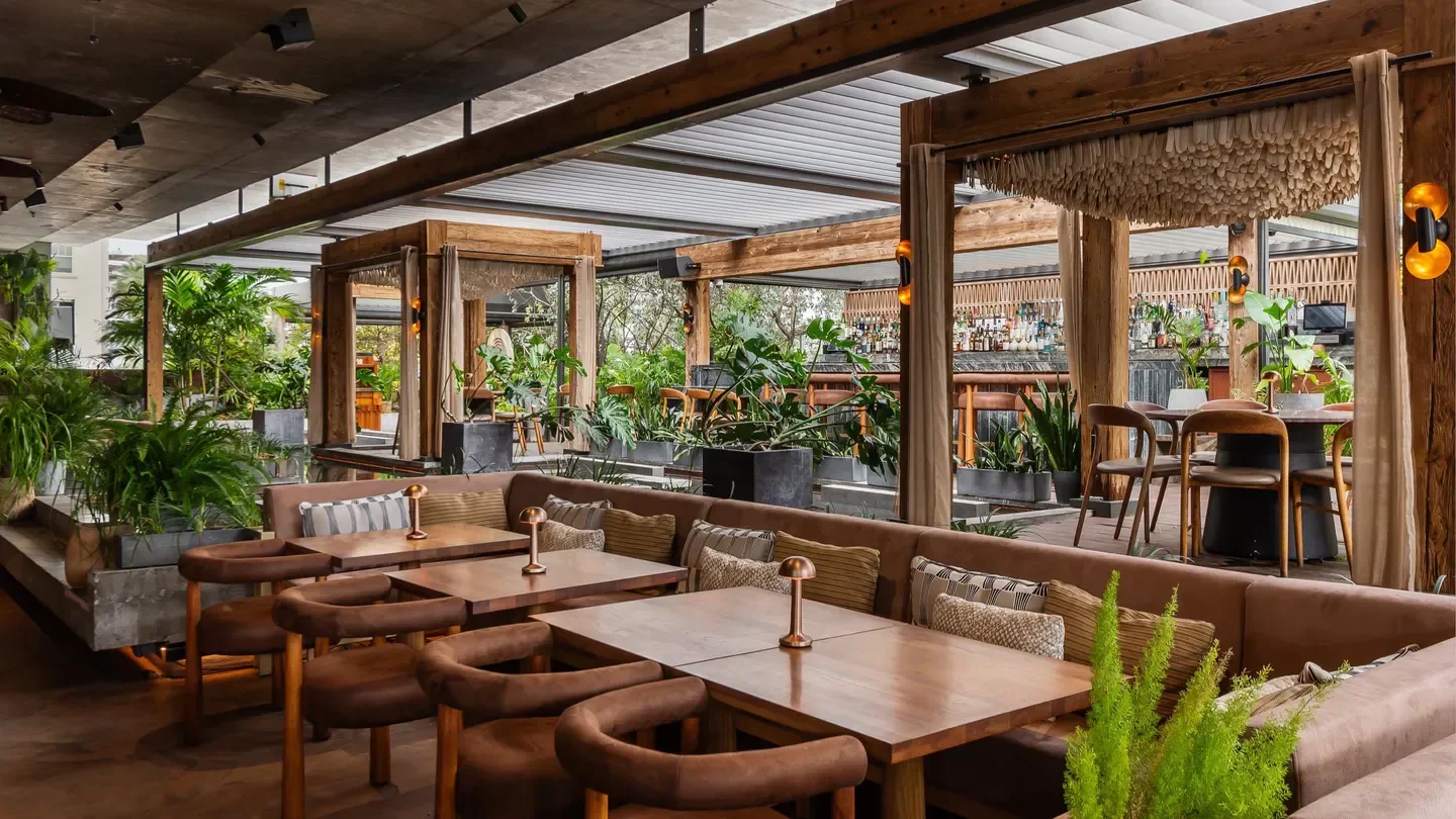 Beautiful interior of MILA restaurant in Miami with lush greenery and elegant tables.