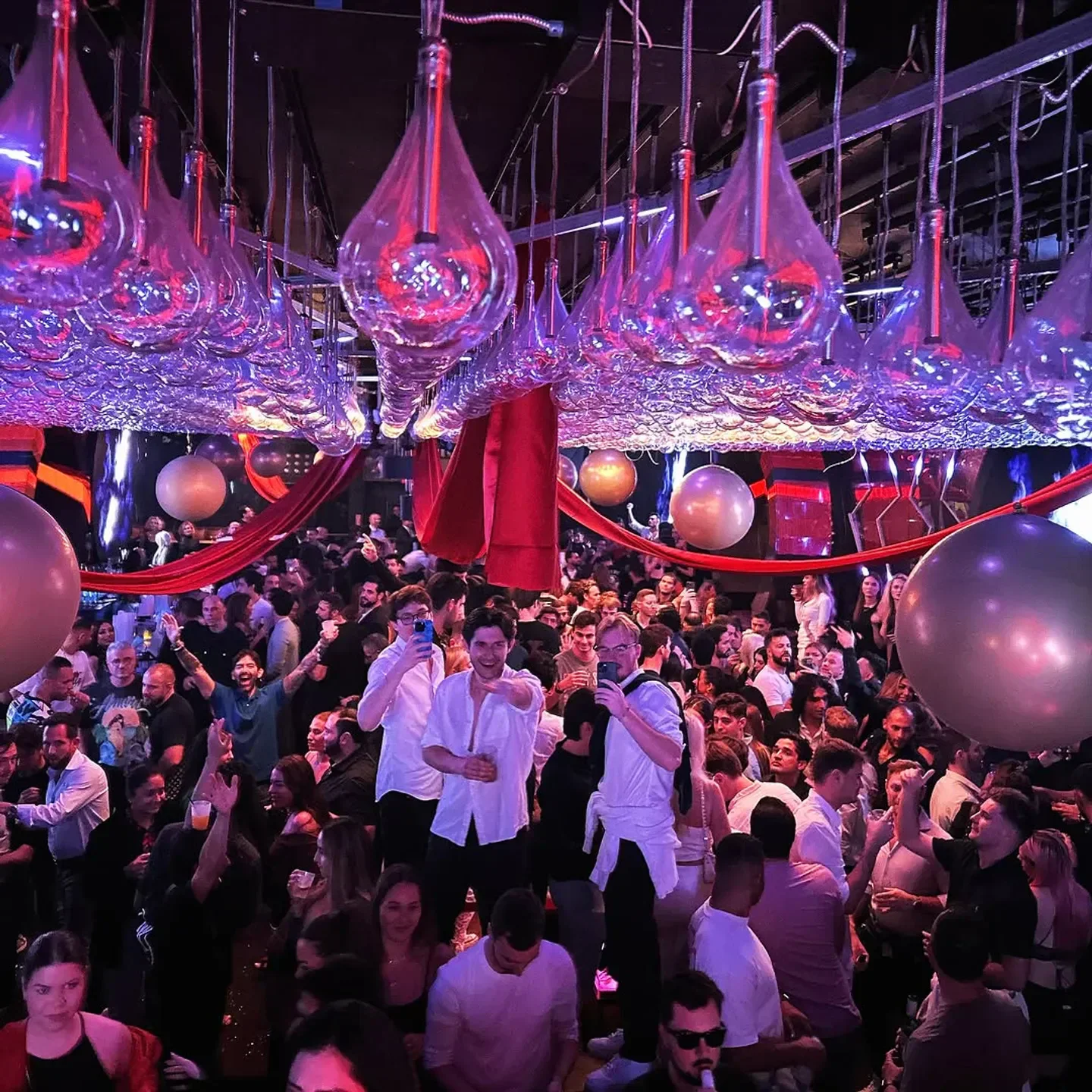 Mynt Lounge nightclub in Miami: A vibrant crowd partying under unique lighting.