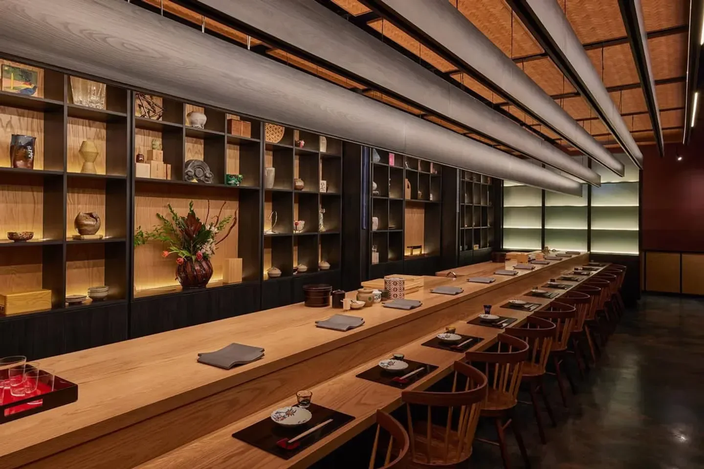 Interior view of Ogawa restaurant in Miami with a long wooden table and shelves.