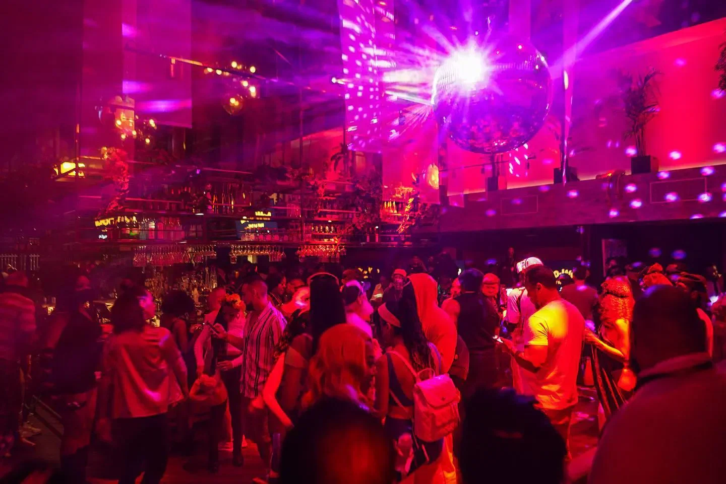 Energetic night at Racket in Miami with a crowded dance floor and disco ball.