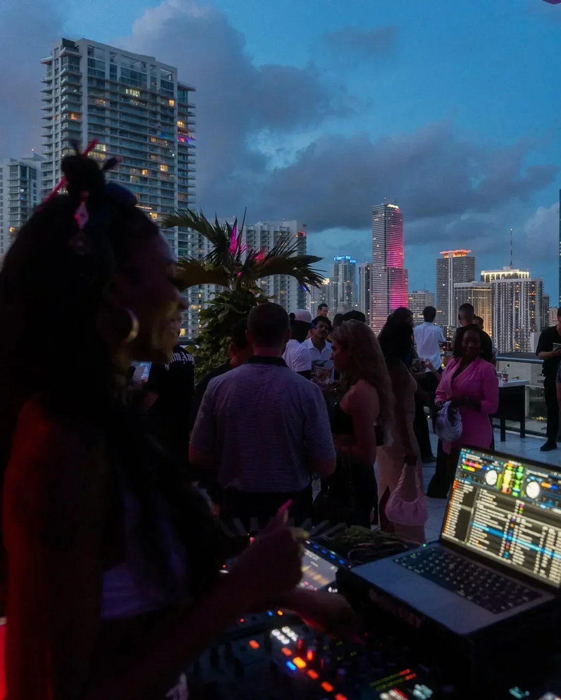 Rooftop party at Rosa Sky in Miami with DJ and city skyline at dusk
