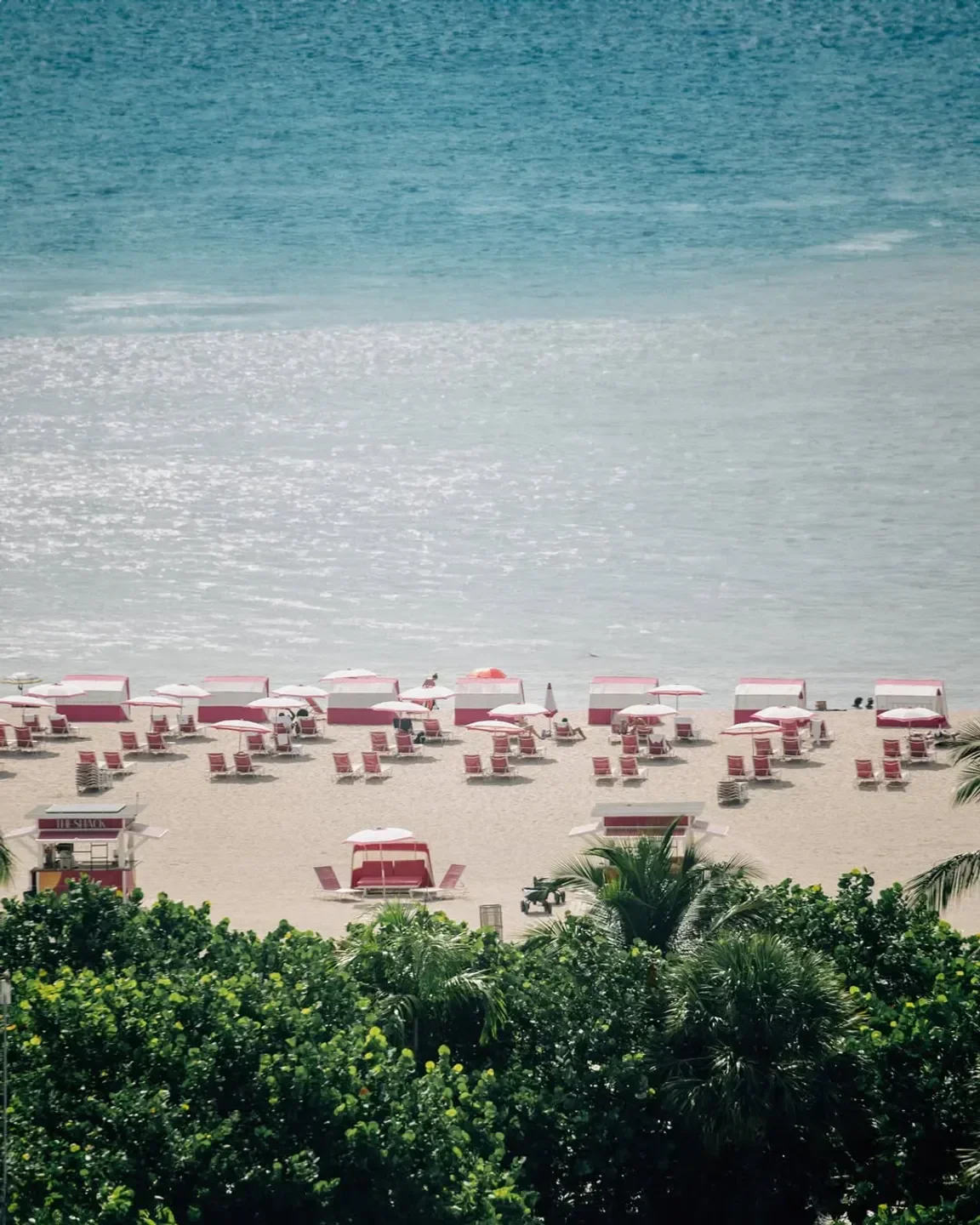 Beach scene at SLS South Beach in Miami with umbrellas and lounge chairs.