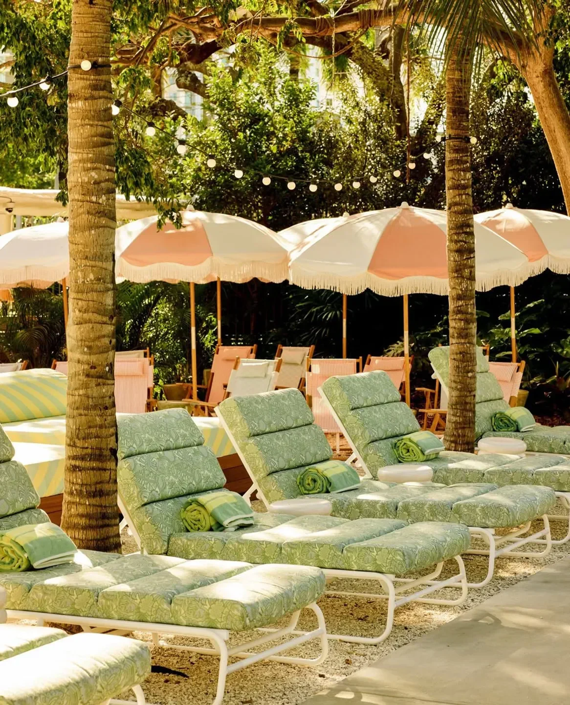 Relaxing lounge chairs and parasols at Soho Beach Club, a Miami beach club.