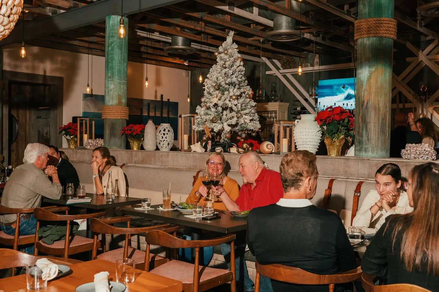 Cozy dining scene at Stiltsville Fish Bar in Miami, with Christmas tree decorations