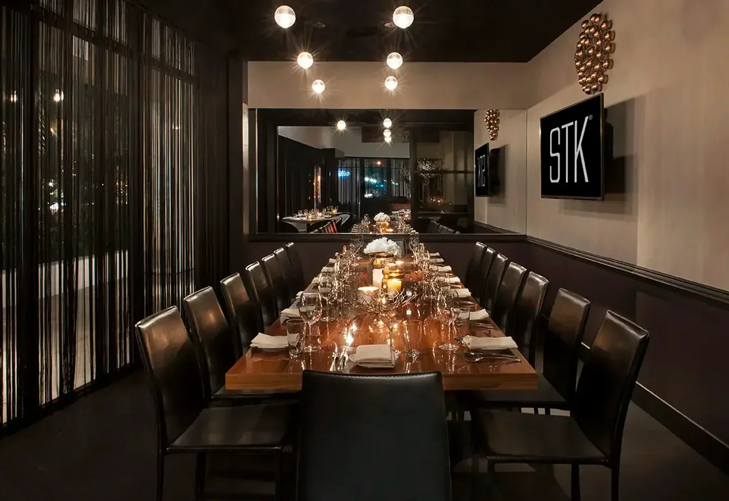 Elegant dining at STK Miami, featuring a long table set for a special occasion.