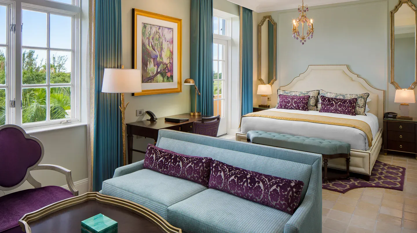 Elegant hotel room at The Biltmore in Miami, featuring a luxury bed and sofa.