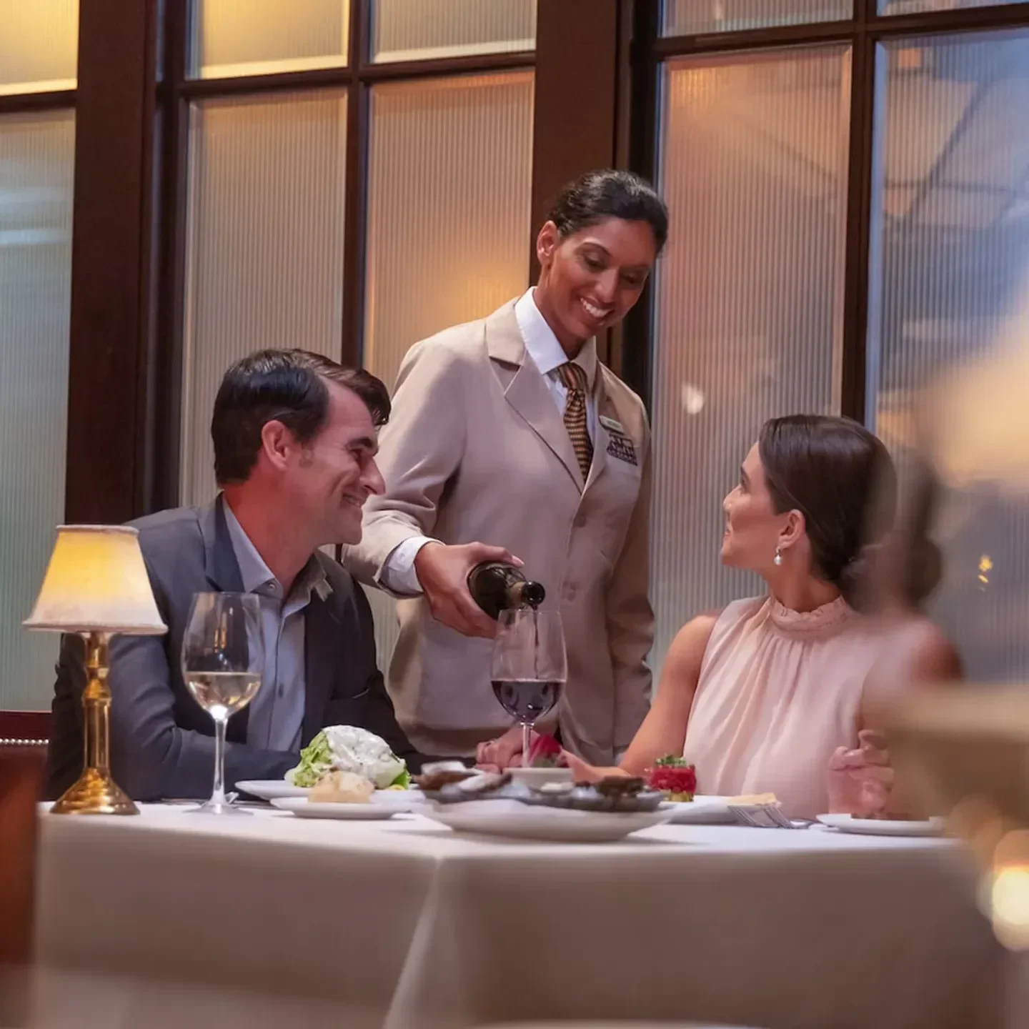 Server pouring wine for guests at The Capital Grille - Miami, a top restaurant in Miami.