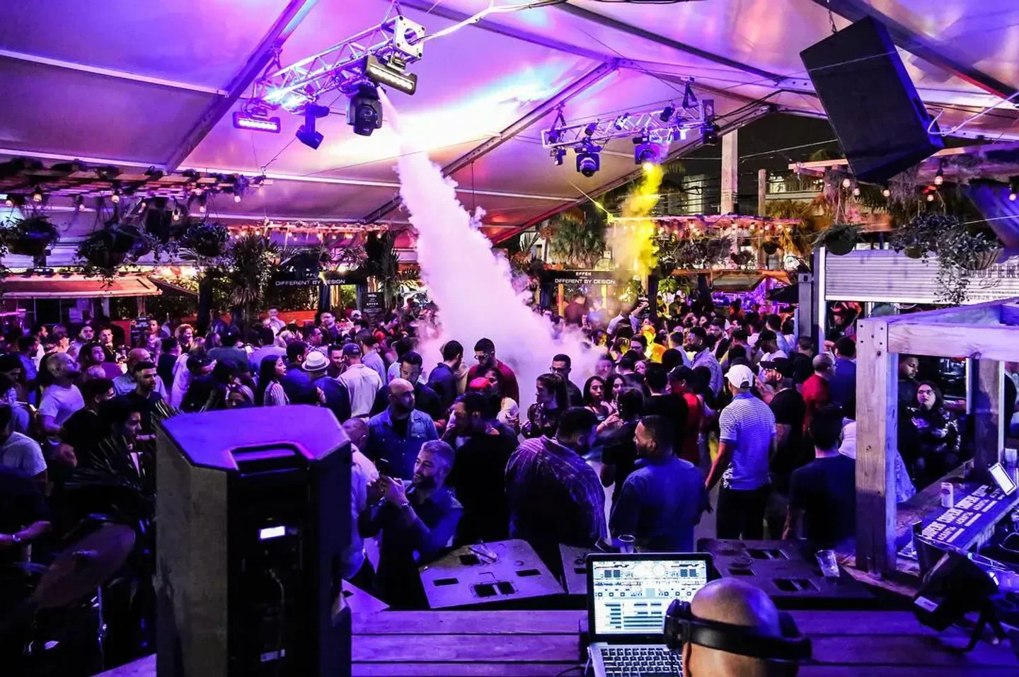 Nightclub scene at The Deck in Miami with a crowd and smoke effect