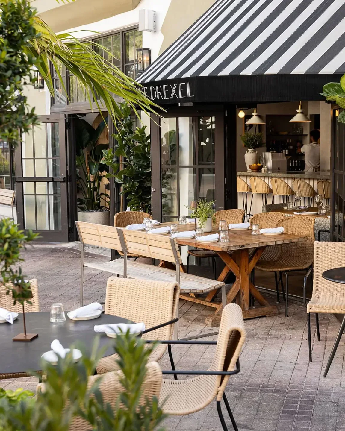 Outdoor dining at The Drexel in Miami, with wicker chairs and stylish decor.