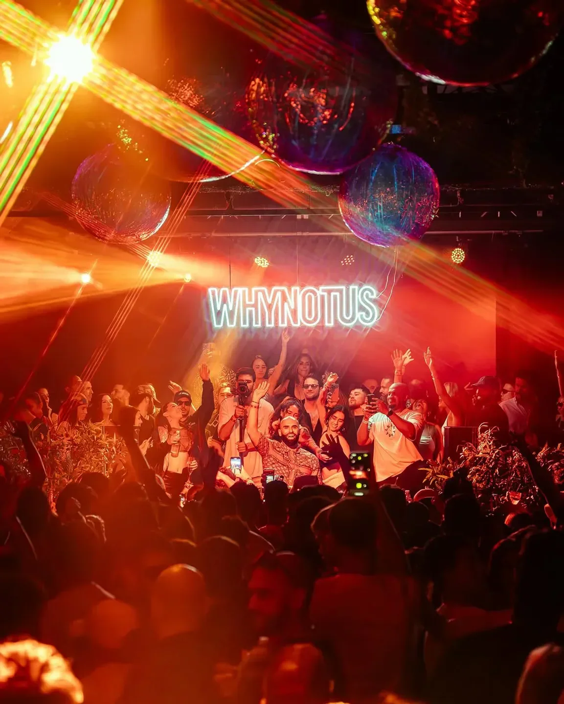 Energetic crowd at The Ground at Space in Miami nightclub with lights and disco balls.