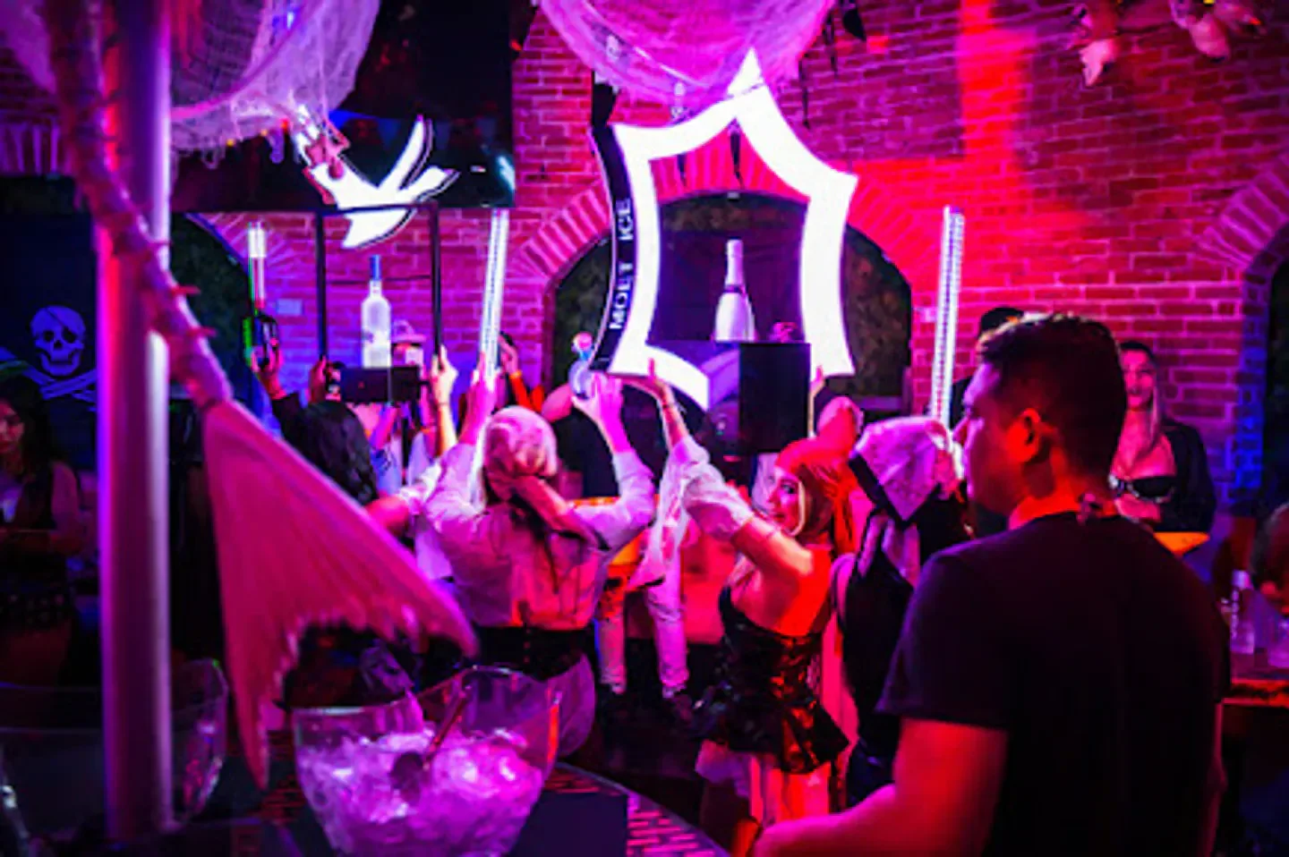 Energetic party at TuCandela nightclub in Miami with people in costumes and drinks.