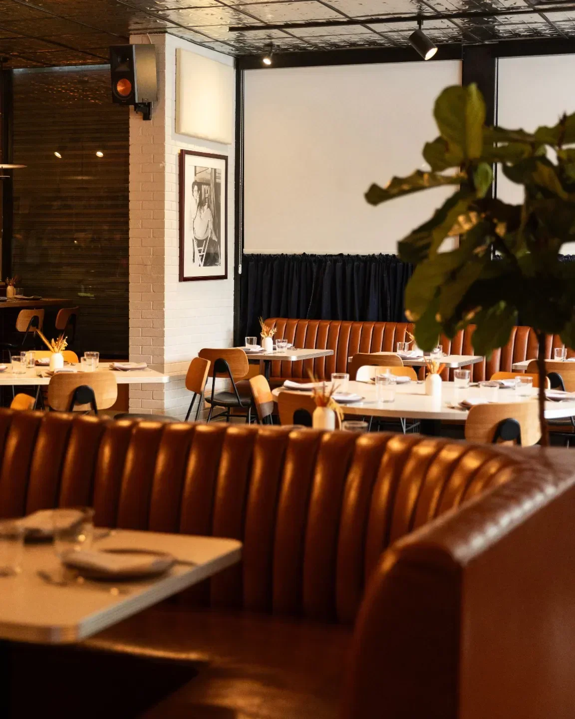 Interior of Walrus Rodeo restaurant in Miami, featuring booth seating and table settings.
